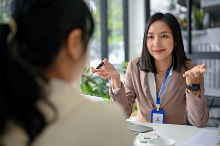 Attractive and professional millennial Asian businesswoman or female HR recruiter interviewing a candidate in the office.の写真素材