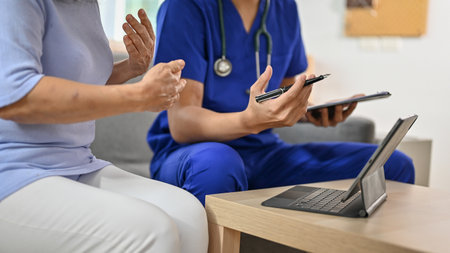 Cropped image of a sick and serious retired old woman having a medical checkup and talking with her doctor in a hospital. health care conceptの写真素材