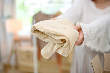 Close-up image of a female small online shop owner showing the process of packing before shipping through a live stream on the shopping platform.の写真素材