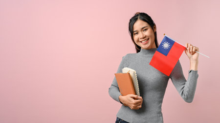 Beautiful Asian girl showing Taiwan flag on pink isolated background, education concept. study abroad concept.の写真素材