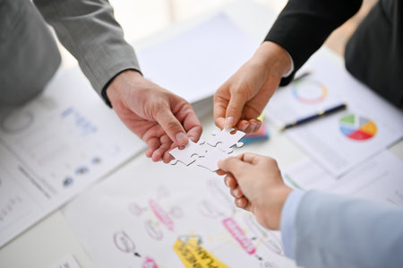 Top view of diverse businesspeople holding a piece of jigsaw puzzle, finding solutions, supporting...