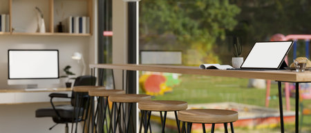 A portable tablet white screen mockup and accessories on a wooden table against the large window in modern co-working room. 3d render, 3d illustrationの写真素材