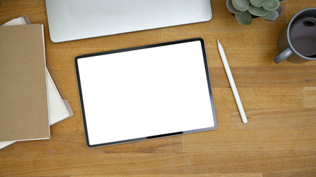 Top view image of a workspace with digital tablet white screen mockup, stylus pen, and accessories...