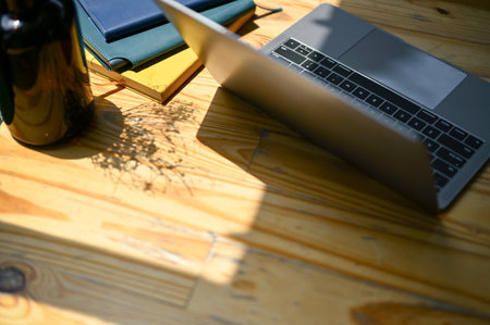 Top view of a laptop computer, books and decor on a wooden tabletop. Minimal workspace conceptの写真素材