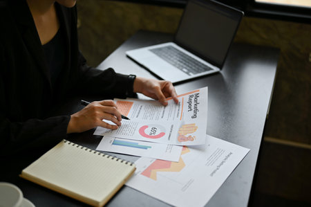 Close-up image of a professional female executive manager is reviewing marketing reports for the new...