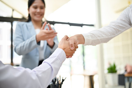 Close-up image of a businessman shaking hands with his colleague or business partner after the...