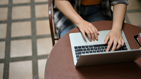 Close-up image of a female freelancer using her laptop computer, remote working at an outdoor cafe.の写真素材