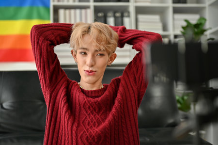 Portrait of an attractive young Asian gay influencer or blogger filming his blog or broadcasting live through his smartphone at home.の写真素材