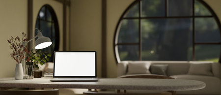 Close-up image of a laptop white screen mockup, table lamp, coffee cup, flower vase and copy space on a table in cozy contemporary living room. 3d render, 3d illustrationの写真素材