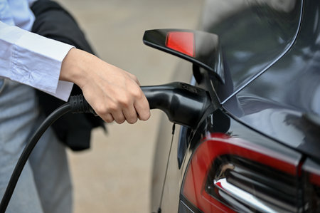 Chiang Mai, Thailand - Jun 12 2023: close-up image of a woman charging her Tesla at the public charger station.のeditorial素材