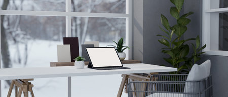 A portable tablet white screen mockup on a white table against the window with snow view, modern minimal home workspace. Modern office in winter season concept. 3d render, 3d illustrationの写真素材