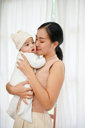 Pretty woman holding a newborn baby in her arms, relax enjoy tender family moment at home, childcare...