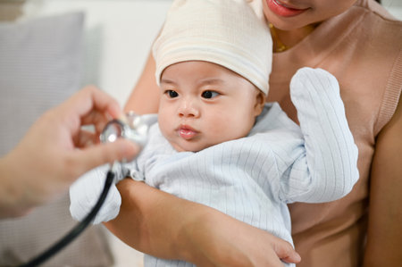 Close up view of adorable baby being checked by a doctor using a stethoscope. Childcare concept.の写真素材
