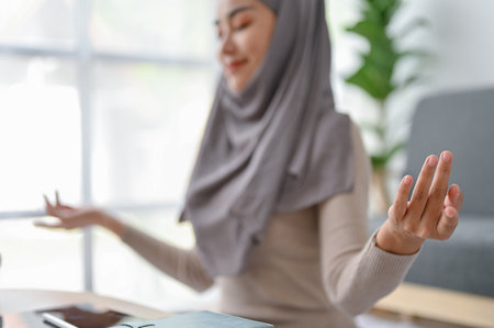 Muslim Woman In Headscarf Meditating With Closed Eyes, Making Mudra Gesture With Fingers. close-up imageの写真素材