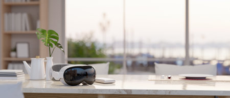 Close-up image of a modern VR goggles is on a beautiful dining table in a modern bright dining room....