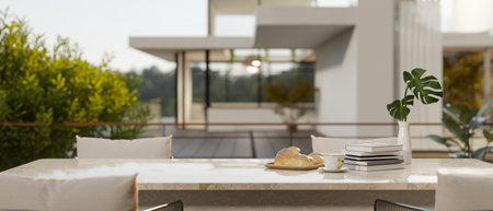 A close-up image of an outdoor dining space with a beautiful white marble dining table on a terrace....