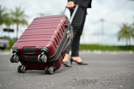 Close-up image of a businesswoman carrying her luggage, boarding a plane for her business trip.の写真素材