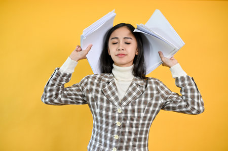 A relaxed Asian businesswoman eyes closed, holding her documents, feeling free after done with her...