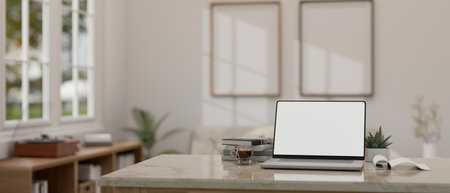 Close-up image of a modern home office with a laptop white screen mockup on a desk with a blurred modern minimal white living room as a background. 3d render, 3d illustrationの写真素材