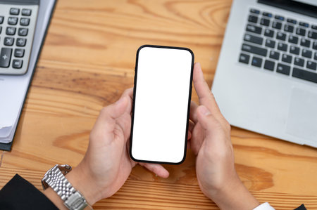 Top view of a businesswoman using his smartphone at his desk. smartphone white screen mockup