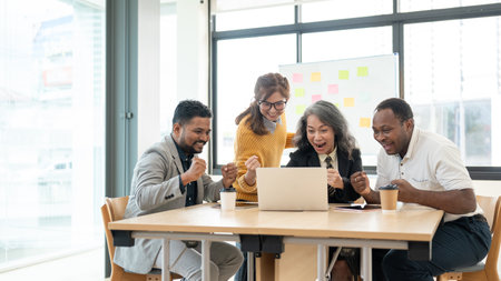 A group of cheerful, diverse businesspeople or startups is looking at a laptop screen with an...