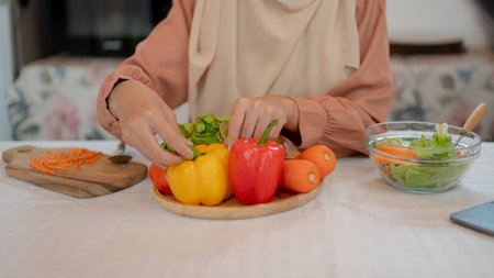 Close-up image of a muslim woman preparing the ingredients for her healthy meal at a table in the kitchen. Home cooking and healthy lifestyle conceptsの写真素材