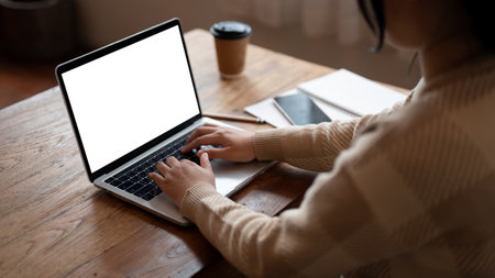 Close-up image of a female freelancer or college student using her laptop, working remotely at a...