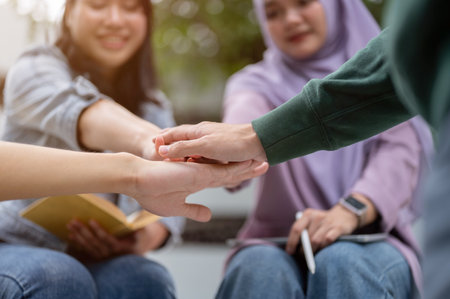 Close-up hand image of a group of cheerful, diverse Asian university students is putting their hands together, encouraging and supporting each other as a team. Friendship conceptの写真素材