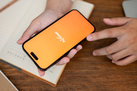 Chiang Mai, Thailand - Oct 18 2023: close-up image of a woman using a Payoneer application on her Iphone14. Payoneer logo on Iphone14 screenのeditorial素材