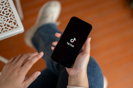 Chiang Mai, Thailand - Oct 19 2023: Close-up image of a woman using the TikTok application or logging in to her TikTok account on her Iphone14. Social media platform conceptのeditorial素材