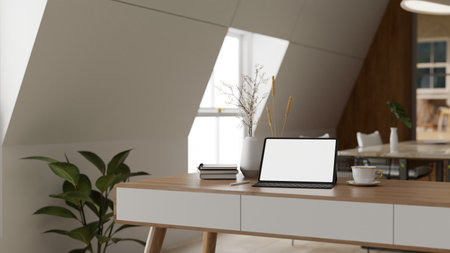 A minimal Scandinavian office with a white-screen tablet, a coffee cup, books, and a ceramic vase on a minimal wooden desk. Home office, workspace 3d render, 3d illustrationの写真素材