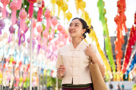 A beautiful and happy young Asian-Thai woman in a traditional Thai-Lanna dress is enjoying in a Thai-Lanna lantern festival or Yi Peng at a temple in Chiang mai. Lanna Loy Krathong festivalの写真素材