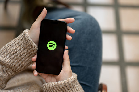 Chiang Mai, Thailand - Nov 21 2023: Close-up image of a woman using Spotify application on her...