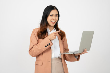 Portrait of a happy Asian businesswoman working on laptop computer, using laptop computer on isolated white background.の写真素材