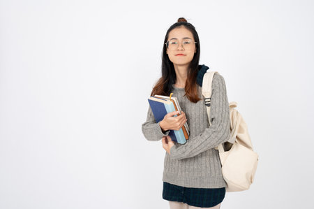 Happy adorable college student with books and backpack on white isolated background.の写真素材