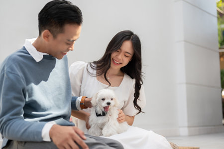 Young Asian couple with cute little dog, spending time as a family together. Couple concept.