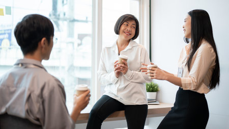 Group of friendly and happy, diverse Asian businesspeople are enjoying chatting during a coffee...