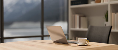 Close-up image of a laptop computer and a coffee cup on a wooden desk in a modern, luxury CEO office...