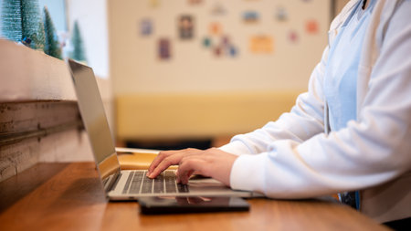 Side view image of a woman using her laptop computer at a table in a coffee shop. Businesswoman, freelancer, student People and technology conceptsの写真素材