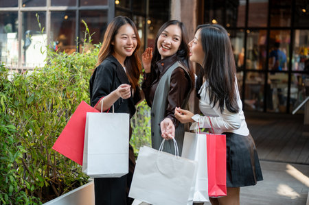 Young happy and attractive three Asian girls are enjoying shopping on the weekend together. city life, lifestyle, fashionの写真素材