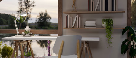 Interior design of a cosy Scandinavian cottage house with a desk near by the window with lake view,...