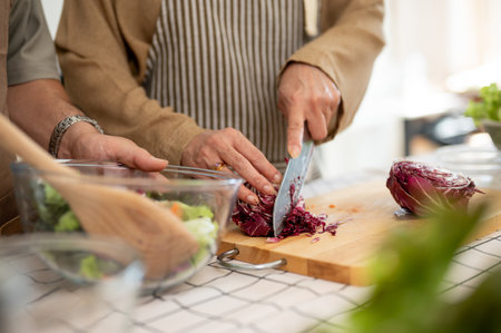 A close-up image of a wife chopping vegetables, cooking, and making a healthy breakfast with her husband in the kitchen. domestic life, home cooking, lifestyleの写真素材