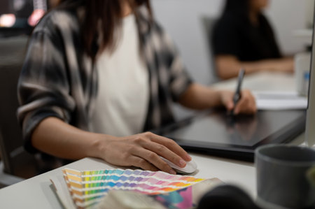 Close-up image of a professional female graphic designer illustrator artist working in the office, drawing something on a graphic tablet.の写真素材