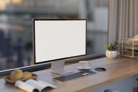 A modern office workspace in the building or apartment with a white-screen computer mockup and...