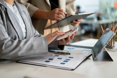 Two professional businesswomen are discussing work and working on a project in the office together. cropped image. business people conceptの写真素材