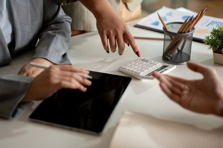 Group of professional businesspeople or financial analysts are discussing and working together in the meeting, showing the number on a calculator. cropped shotの写真素材