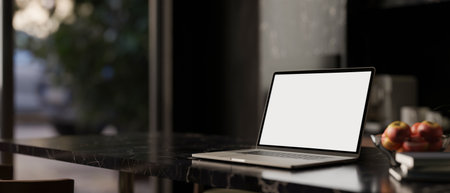 Close-up image of a white-screen laptop computer mockup on a black marble tabletop in a modern black dining room. remote workplace, home workspace. 3d render, 3d illustrationの写真素材