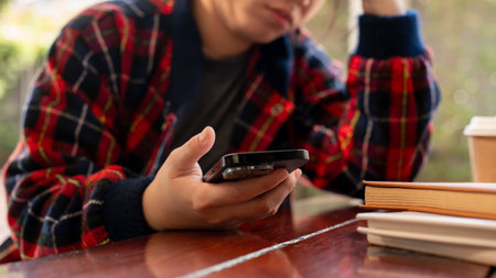 A cropped shot of a stressed Asian woman waiting for an important message on her phone or receiving...