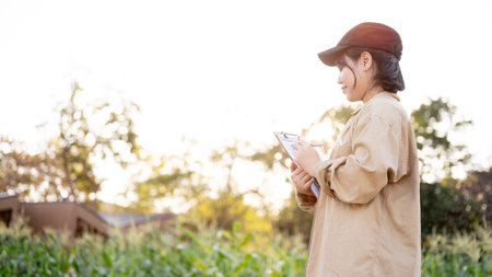 A young Asian female flower farm owner or agronomist working in a flower farm, checking the quality of the flower.の写真素材