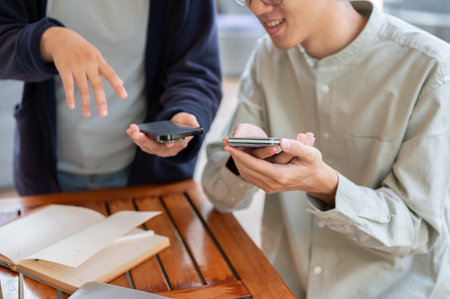 A cropped shot of two people sharing contact info or transferring files by bringing two smartphones close together. people and modern technology conceptsの写真素材